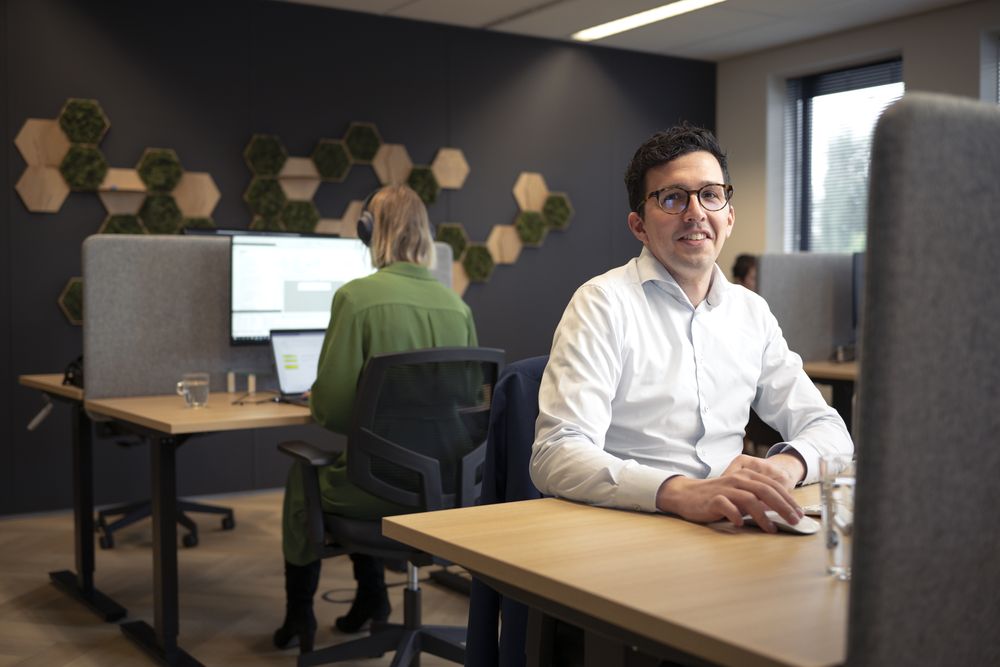 Collega's aan het werk achter hun beeldschermen in de kantoortuin