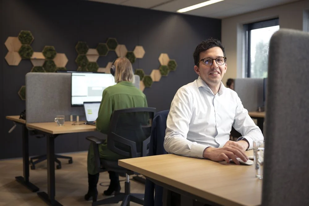 Collega's aan het werk achter hun beeldschermen in de kantoortuin