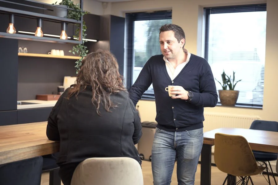 Twee collega's in gesprek met een kop koffie
