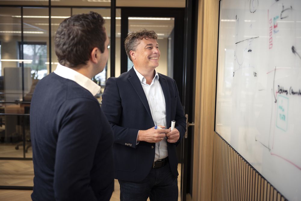 Twee collega's overleggen bij het whiteboard