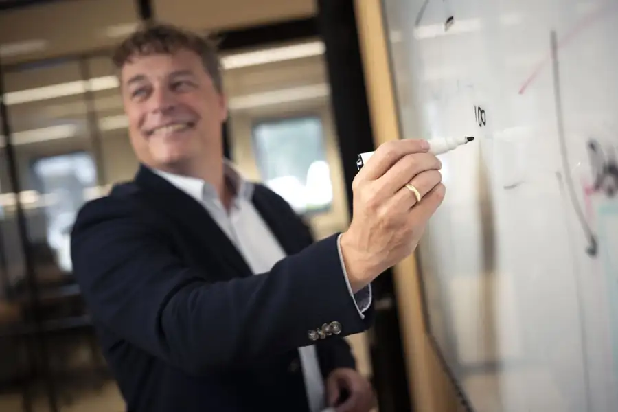 Collega van 4SURE schrijft de planning op een whiteboard